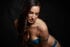 Dark boudoir photo of a caucasian brunette woman in blue lingerie