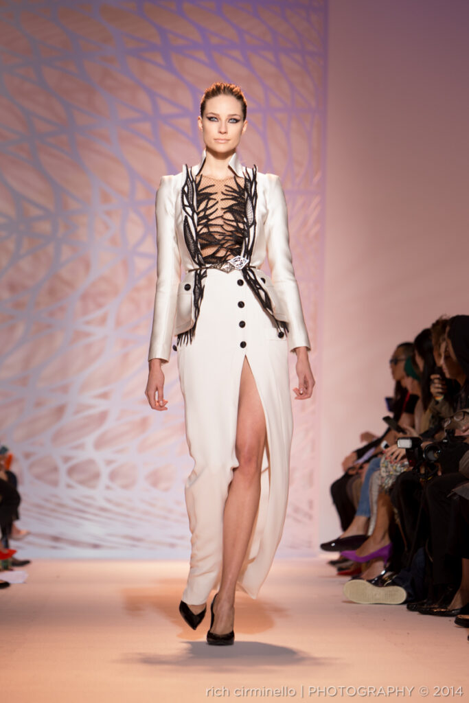 Model in a white Zuhair Murad gown with black leaf detailing at Paris Haute Couture Fashion Week 2014, photographed by Rich Cirminello