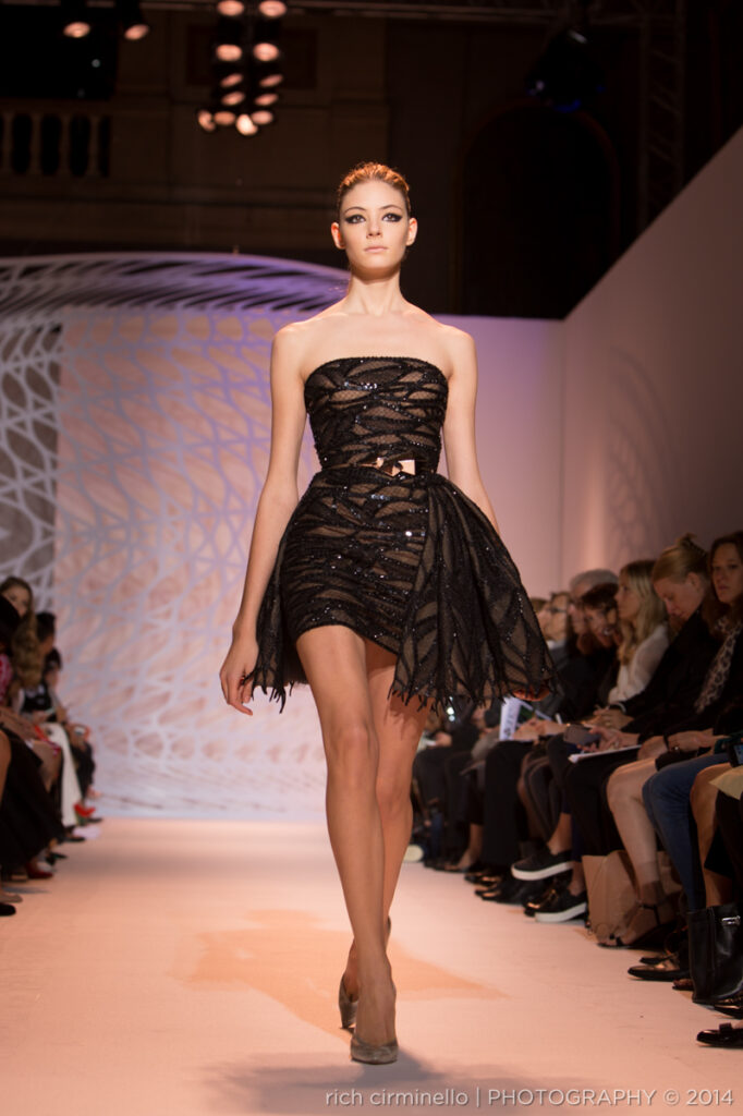 Model in a strapless black Zuhair Murad mini-dress with intricate cutouts at Paris Haute Couture Fashion Week 2014, photographed by Rich Cirminello