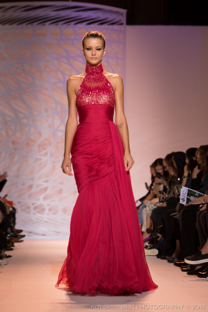 Model walking in a high-neck Zuhair Murad fuchsia gown at Paris Haute Couture Fashion Week 2014, photographed by Rich Cirminello.