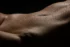 Close detail of water droplets on skin along the torso, fine art bodyscape