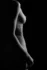 Standing figure rim-lit against black, fine art body photography